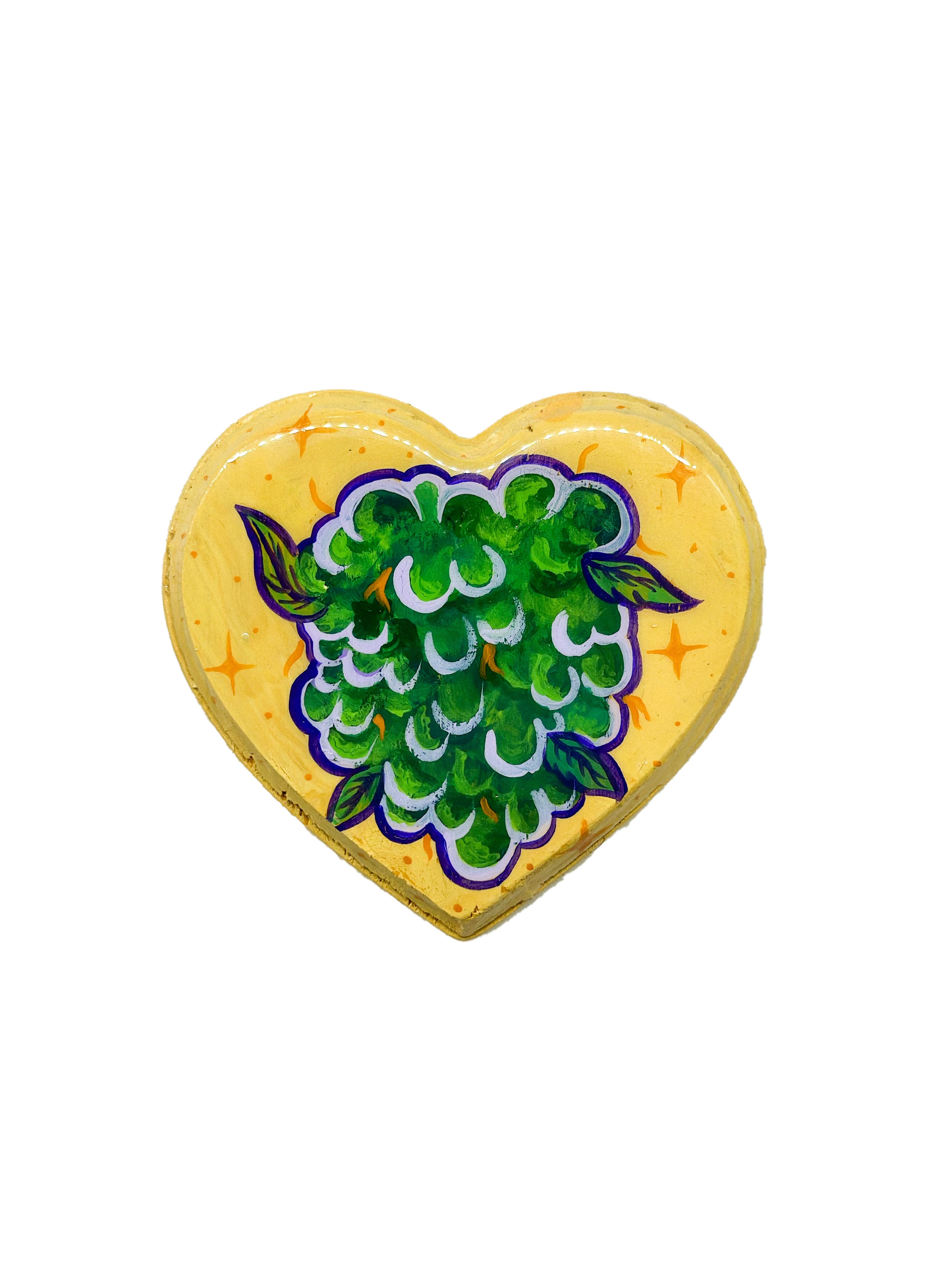 Bright green and purple marijuana nug on a yellow heart shaped canvas